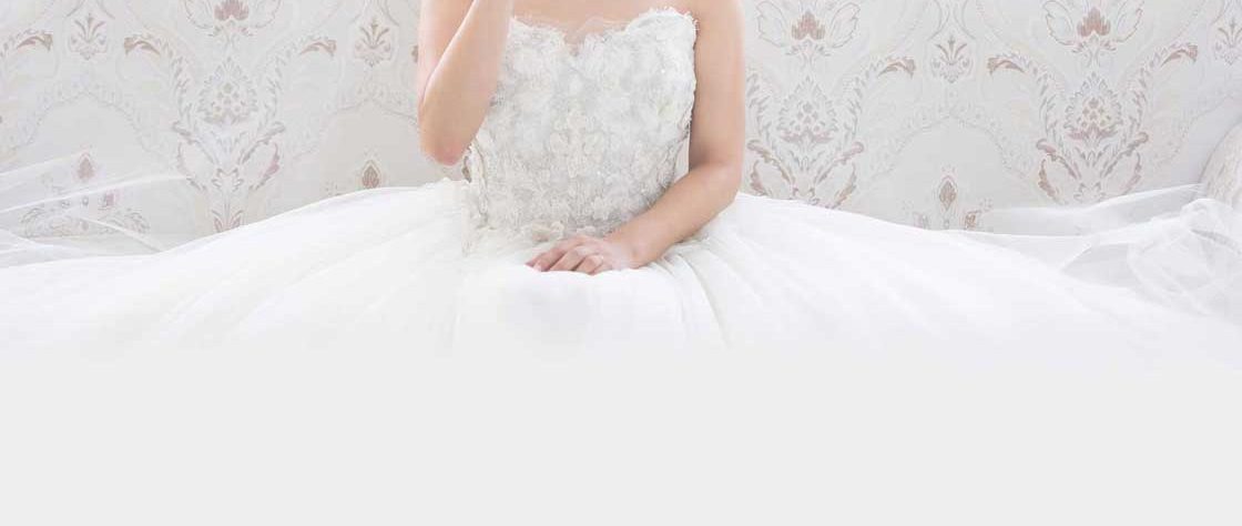 Bride sat on white settee.
